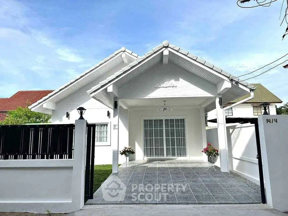 Charming white bungalow with spacious driveway and lush garden, perfect for family living.