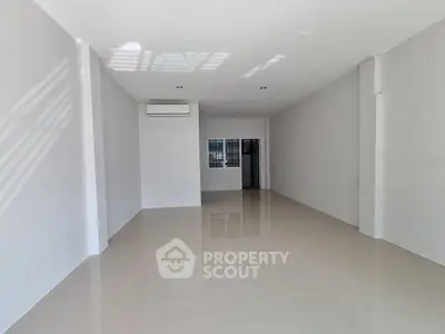 Spacious unfurnished room with sleek tile flooring and air conditioning, perfect for customization.