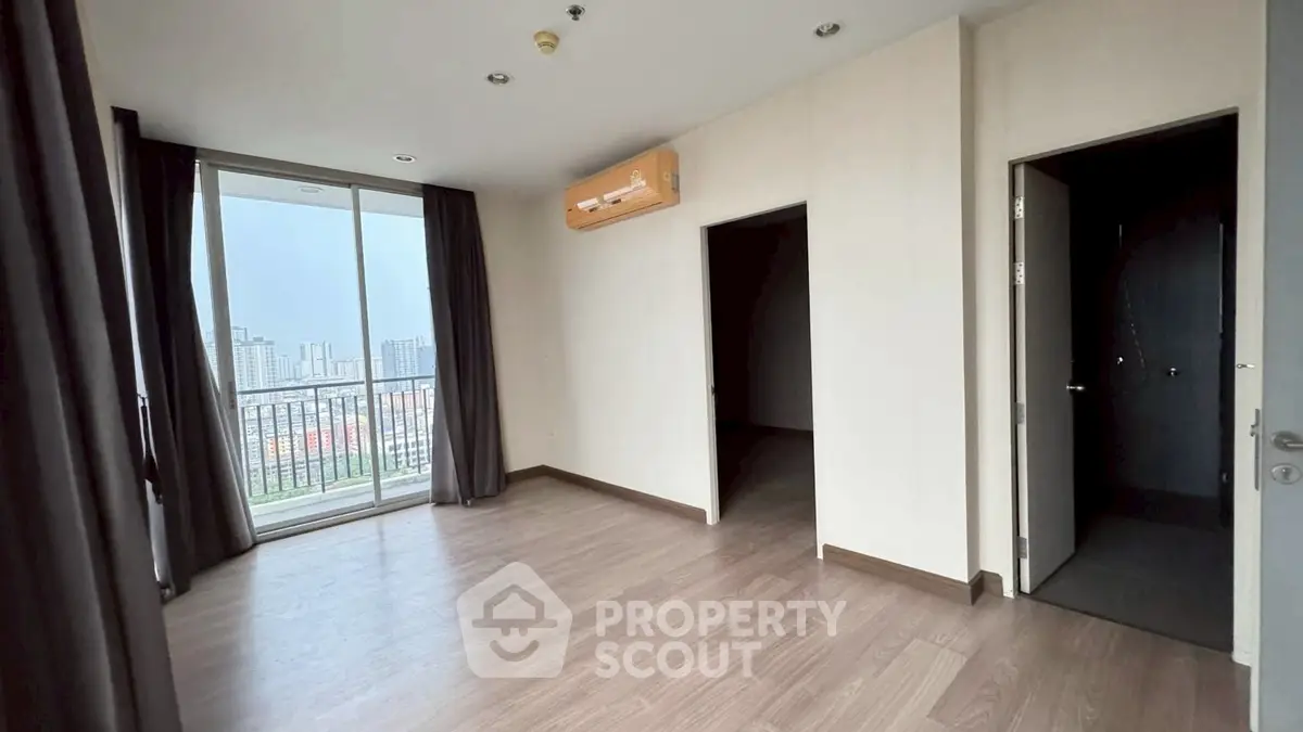 Spacious apartment with balcony and city view, featuring modern flooring and air conditioning.
