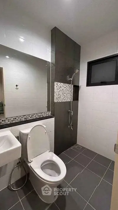 Modern bathroom with sleek design, featuring a shower and contemporary fixtures.
