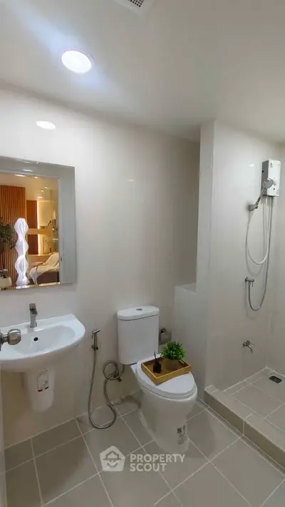 Modern bathroom with sleek fixtures and walk-in shower in a stylish apartment.