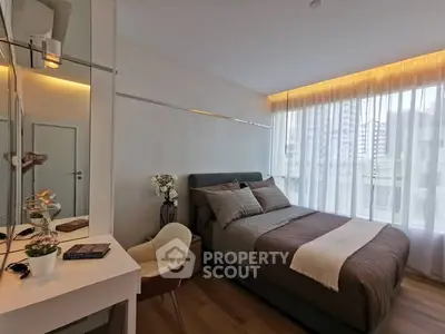 Modern bedroom with stylish decor and large window offering city view