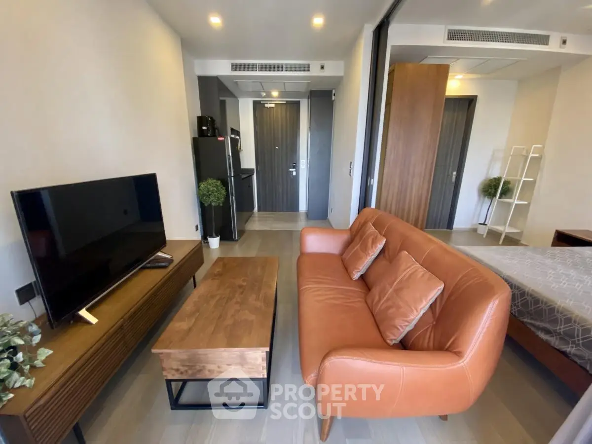 Modern studio apartment with stylish furniture and open layout, featuring a cozy living area and bedroom.