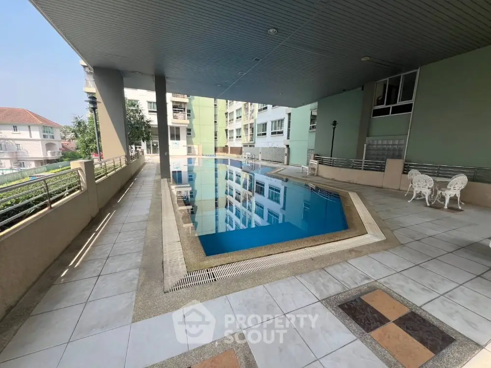 Luxurious residential building with modern swimming pool and spacious deck area.