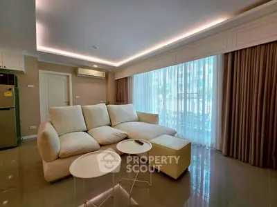 Spacious living room with modern sofa and natural light through large windows.