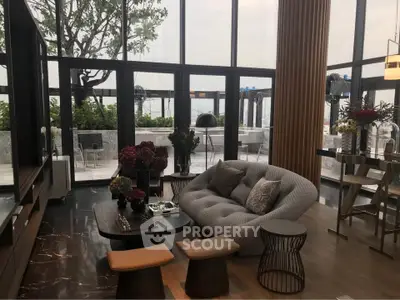 Luxurious living room with modern furniture and large windows overlooking a scenic balcony.