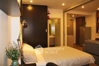 Modern studio apartment with cozy bedroom and open living space, featuring stylish decor and ambient lighting.