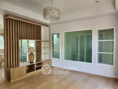 Spacious living room with modern wooden paneling and elegant lighting