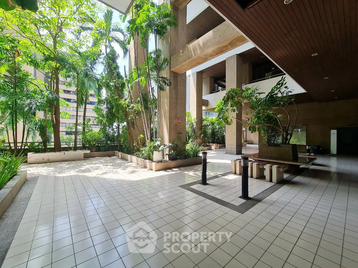 Spacious building entrance with lush greenery and modern design