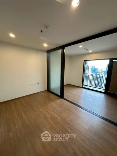 Spacious modern apartment with sliding glass doors and city view balcony.