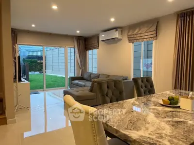Luxurious living room with elegant marble dining table and garden view, perfect for modern family living.