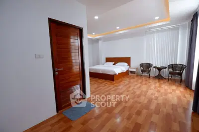 Spacious bedroom with wooden flooring and modern decor