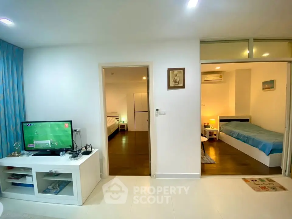 Modern apartment interior with cozy living room and bedroom, featuring sleek furniture and ambient lighting.