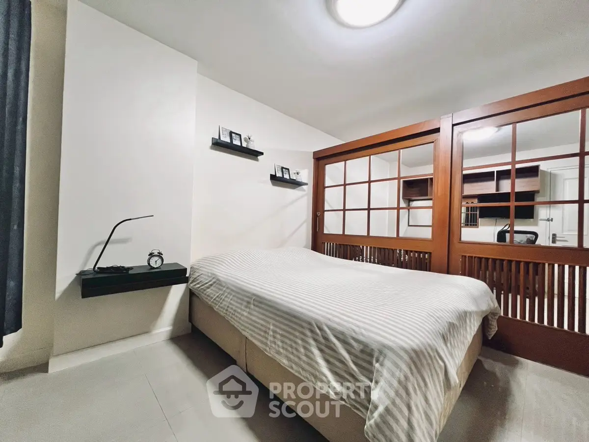 Modern bedroom with stylish decor and sliding wooden doors