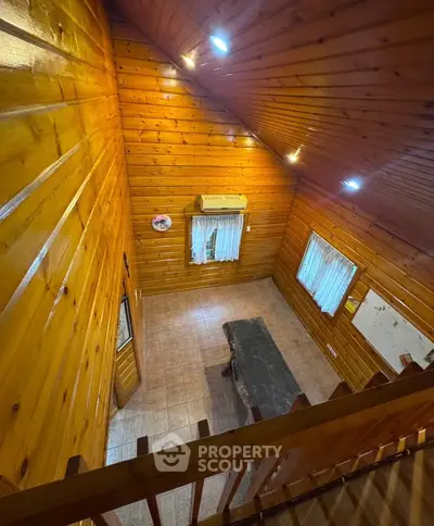 Charming wooden interior with high ceiling and cozy ambiance, perfect for rustic living.