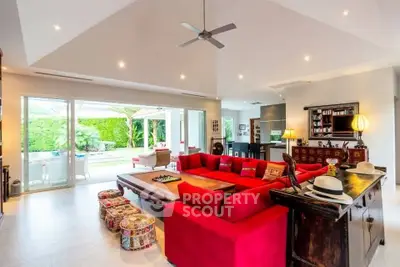 Spacious living room with red sectional sofa and garden view, perfect for entertaining.