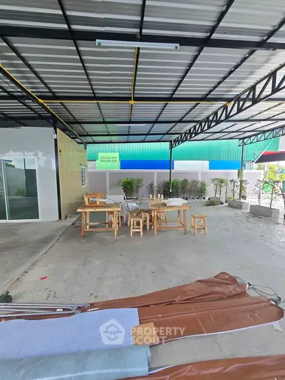 Spacious covered outdoor area with modern design and seating, ideal for gatherings or relaxation.