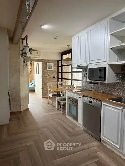 Spacious kitchen with modern appliances and open layout leading to a cozy dining area.