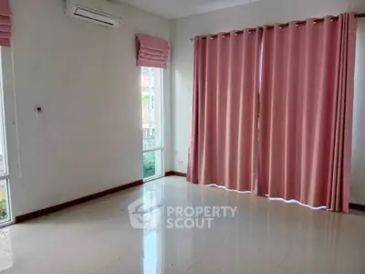 Spacious empty room with pink curtains and air conditioning, ideal for customization.