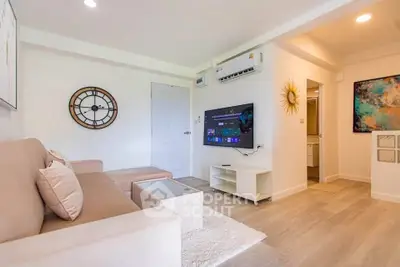 Modern living room with stylish decor and wall-mounted TV in a cozy apartment.
