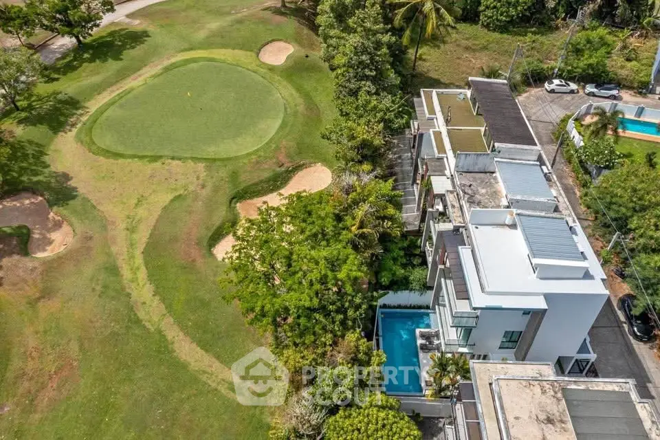 Luxurious property with private pool adjacent to golf course, offering stunning views and modern architecture.