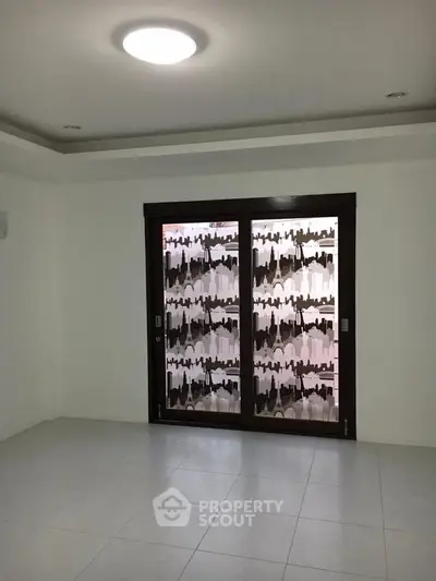 Spacious empty room with large window and modern tile flooring