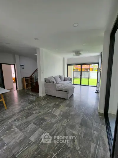 Spacious modern living room with large windows and stylish gray flooring