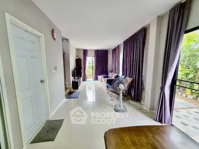 Spacious living room with elegant decor and large windows offering garden views.