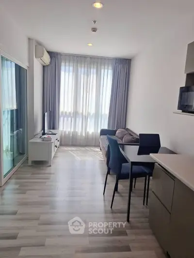Modern living room with natural light, sleek furniture, and stylish decor in a contemporary apartment.