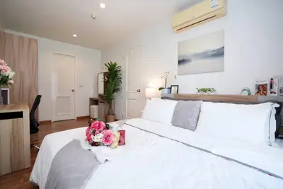 Cozy bedroom with modern decor, featuring a comfortable bed, stylish desk, and elegant wall art.