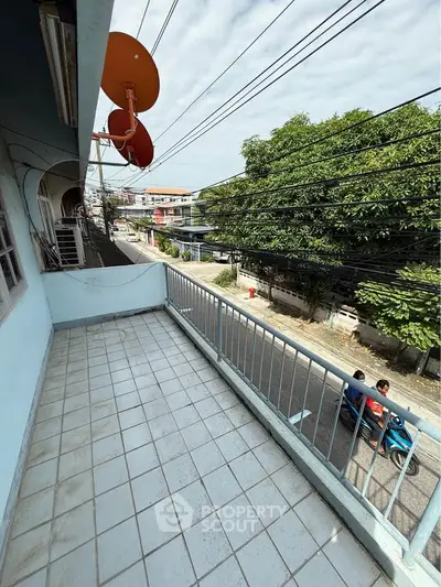 Spacious balcony with street view and satellite dishes, perfect for urban living.