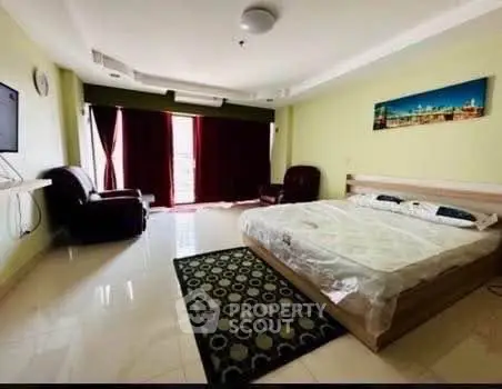 Spacious bedroom with modern decor and large window for natural light
