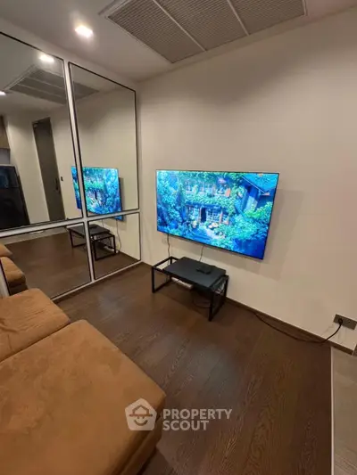 Modern living room with wall-mounted TV and mirrored closet doors
