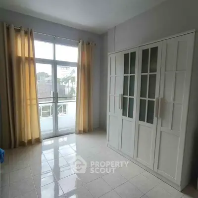 Bright bedroom with large window and spacious wardrobe in modern apartment