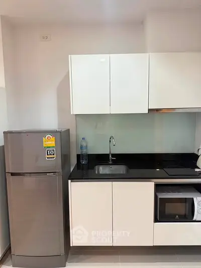 Modern kitchen with sleek cabinets, stainless steel fridge, and built-in appliances.
