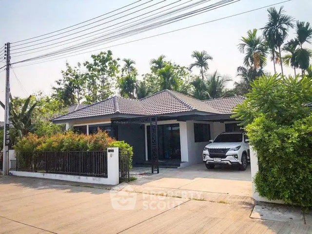 Charming single-story house with lush garden and driveway in a serene neighborhood.