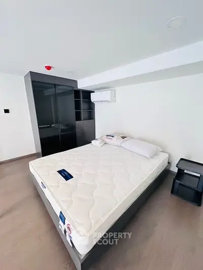 Modern bedroom with sleek design and air conditioning in a contemporary apartment.