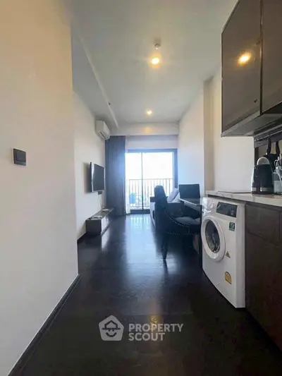 Modern living room with balcony and washing machine, sleek design and natural light.
