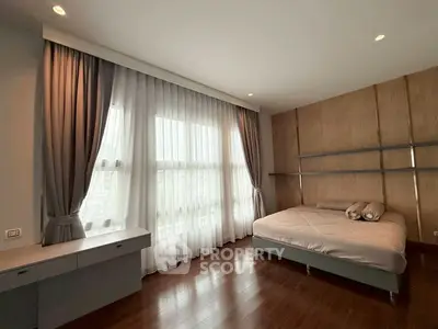 Spacious bedroom with large window and elegant curtains in modern apartment