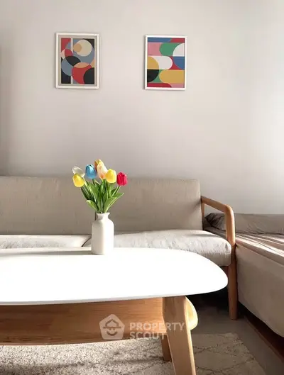 Cozy living room with modern art and tulip centerpiece on wooden coffee table.
