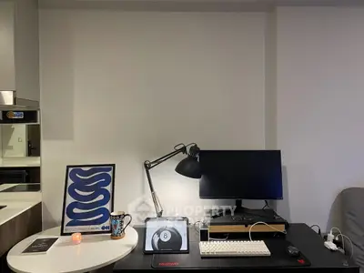 Modern study area with sleek desk, monitor, and stylish decor in contemporary apartment.