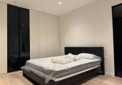 Modern bedroom with sleek black and white design, featuring a comfortable bed and spacious wardrobe.