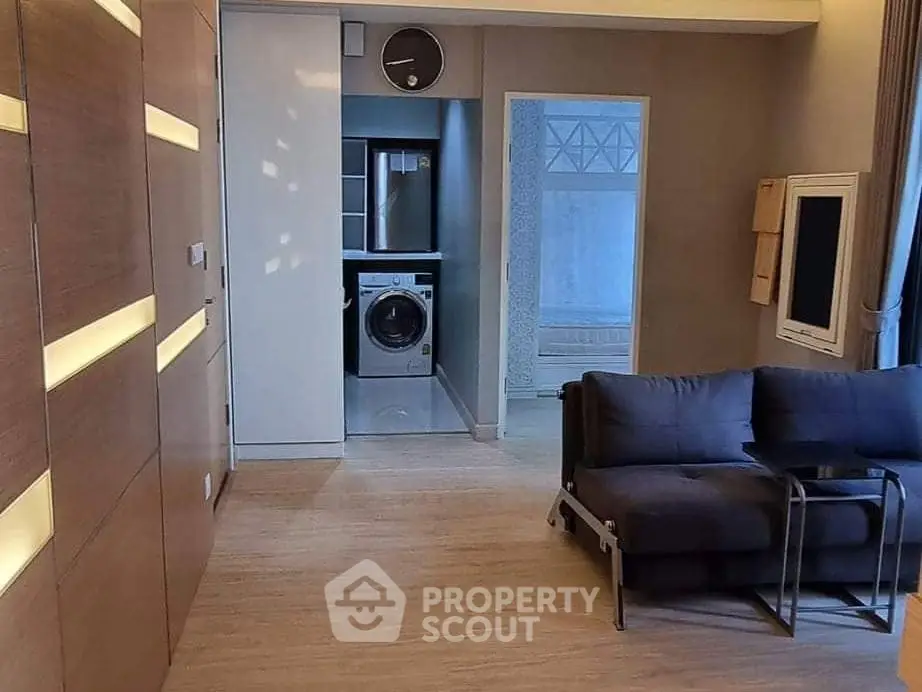 Modern living room with sleek design and in-unit washing machine, featuring cozy seating and stylish decor.