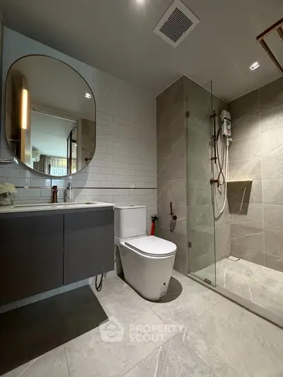 Modern bathroom with sleek design, featuring a glass shower enclosure and stylish fixtures.