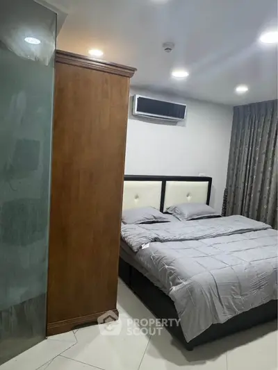 Modern bedroom with stylish decor and air conditioning unit, featuring cozy bedding and elegant curtains.
