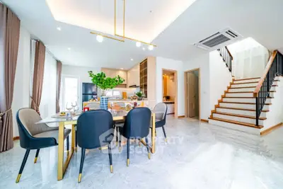 Spacious modern dining area with elegant staircase and open kitchen layout