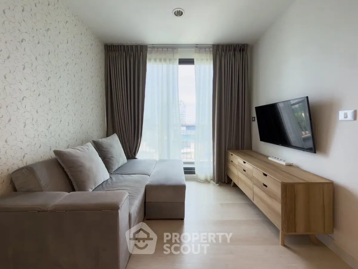Modern living room with stylish sofa and wall-mounted TV, featuring floor-to-ceiling windows and elegant curtains.