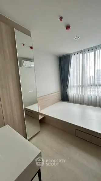 Modern minimalist bedroom with large window and sleek furnishings