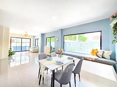 Spacious modern living room with dining area and large windows offering natural light.