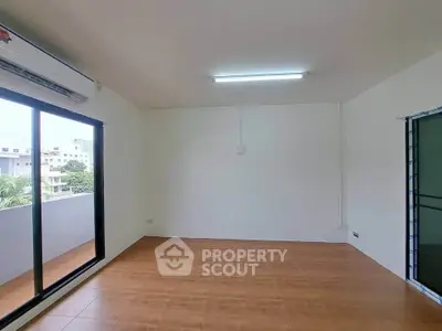 Spacious empty room with large window and balcony access, ideal for customization.